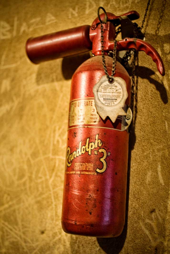 A Red Antique Randolph 3 Fire Extinguisher On A Wall