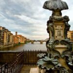 a Benvenuto Cellini statue sits on the Ponte Vecchio bridge along the Arno River in Florence, Italy