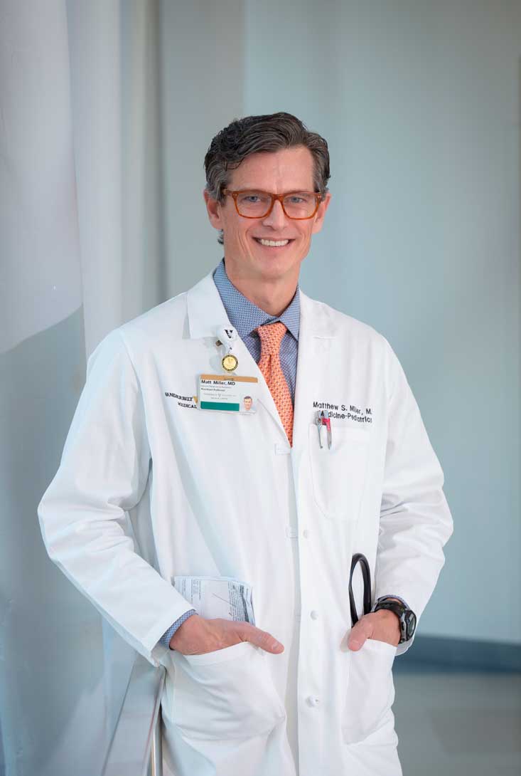 Doctor Matthew Miller in a white lab coat and glasses in the corridor of Vanderbilt Hospital