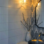 small half bath nickel metal vessel sink marble countertop white vase faux branches light fixture