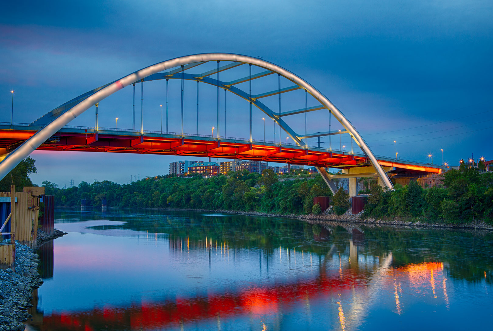 Nashville Korean War Veterans Bridge at sunrise with lights on and colorful reflections in the river
