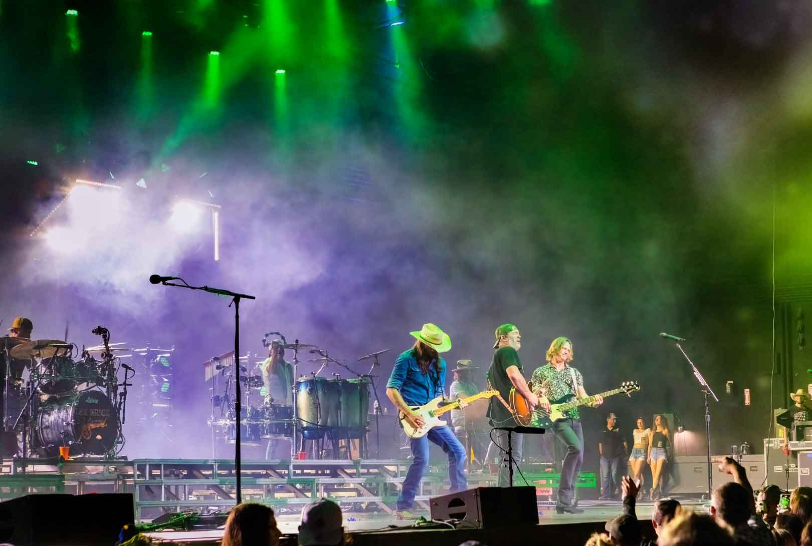 Lee Brice playing live onstage under green purple and white lights with his band