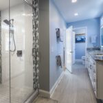 A remodeled master bathroom with blue gray walls, and gray and white tile at a home