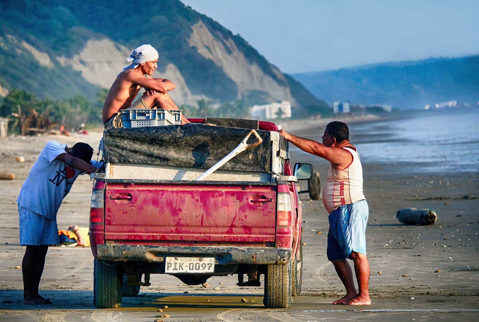 Three Men With Their Red Truck On Canoa Beach In Ecuador