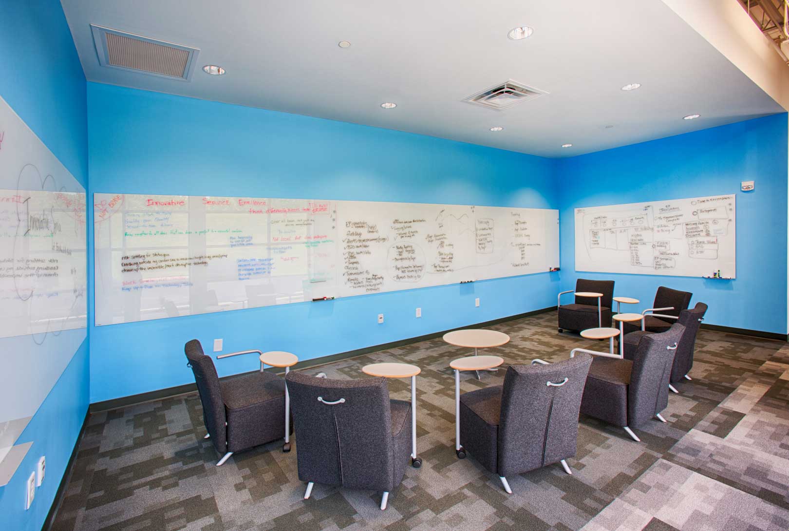 Remodeled Conference Room space with blue walls and gray desk chairs at HCA