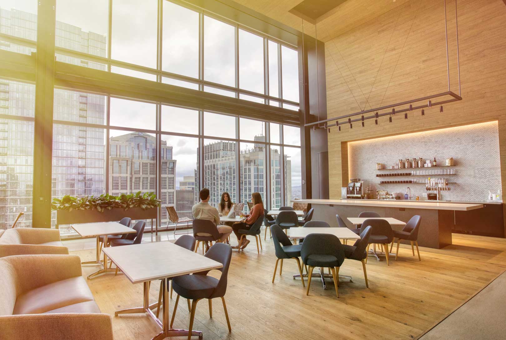 break room seating area with tables, coffee bar, and downtown view in AllianceBernstein building Nashville