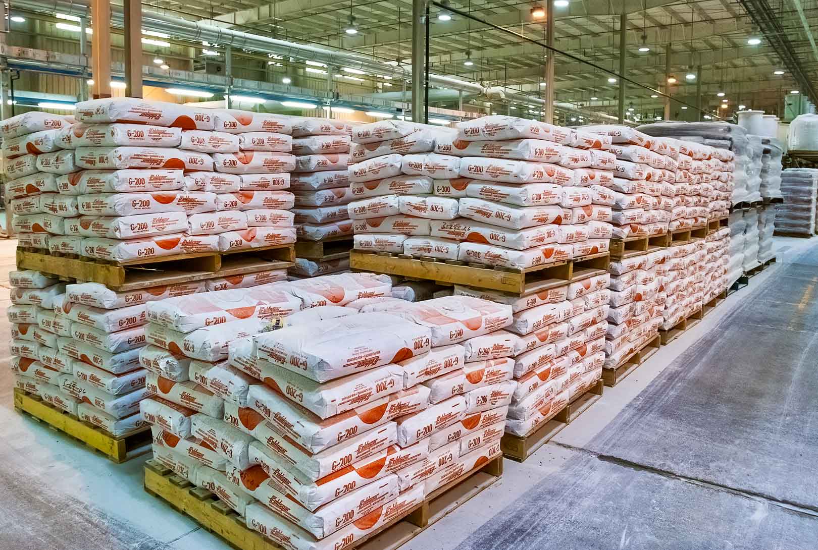 stacks of G200 feldspar stacked on pallets in tile manufacturing warehouse