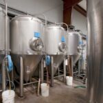 several rows of beer distillery tanks in the warehouse