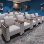 theater room with blue walls, white theater chairs, a podium, and Hollywood imagery on the walls
