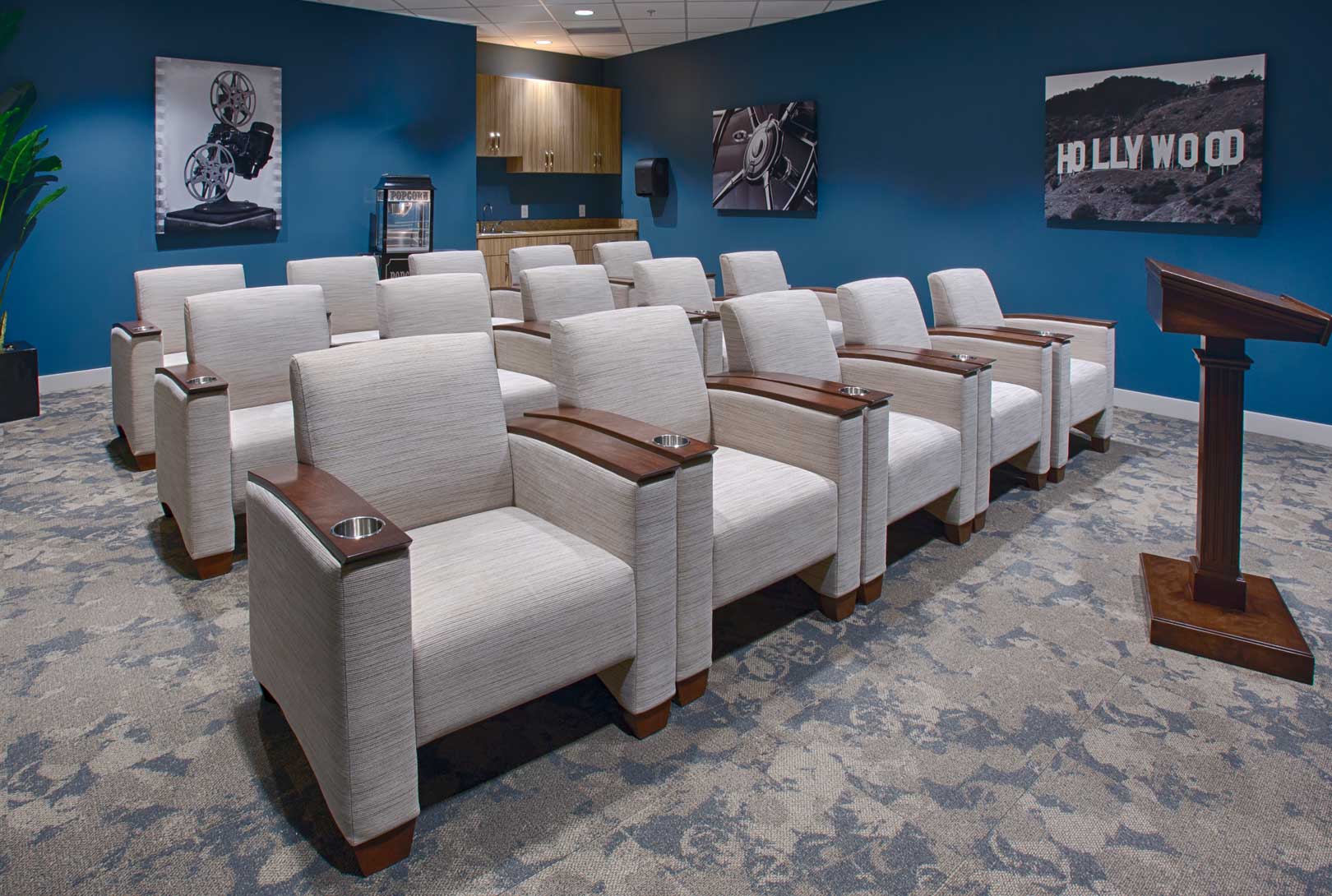 theater room with blue walls, white theater chairs, a podium, and Hollywood imagery on the walls