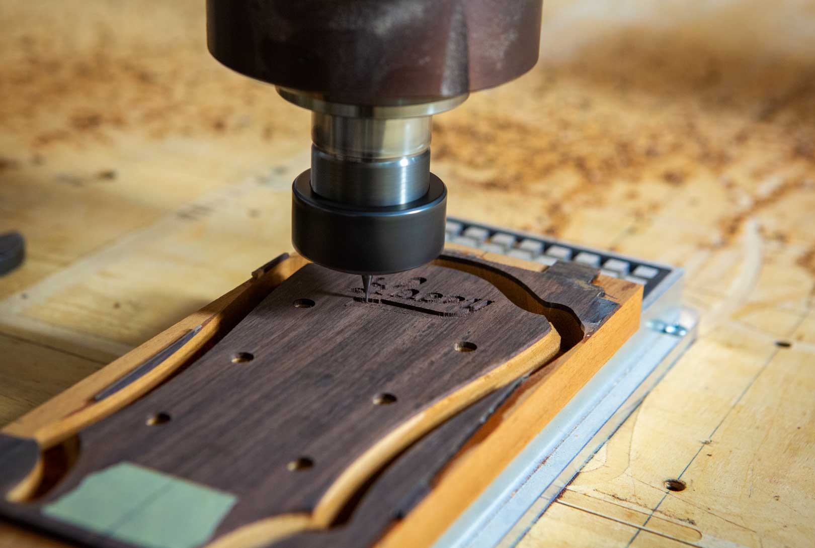 A CNC Machine Milling A Logo Into A Guitar Neck