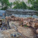 concrete construction fabrication of waterfall, boulder formations, and tree stump