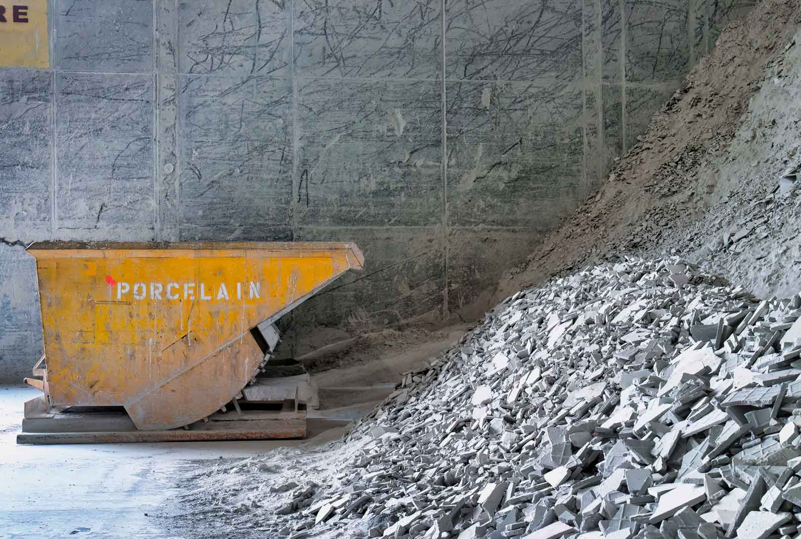 raw materials are piled in holding area near a yellow container