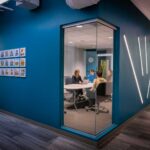 blue-painted wall with a corner window view into conference room with led light accents