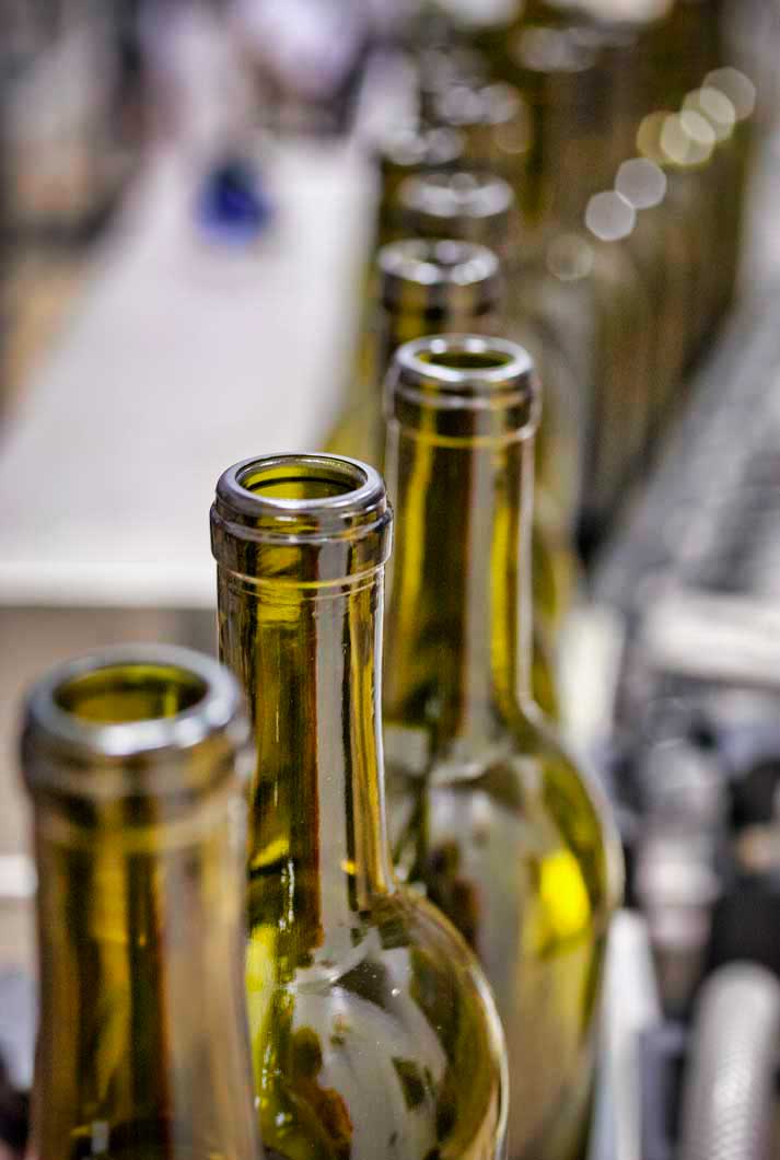 Green Wine Bottles Lined Up On A Bottling Machine