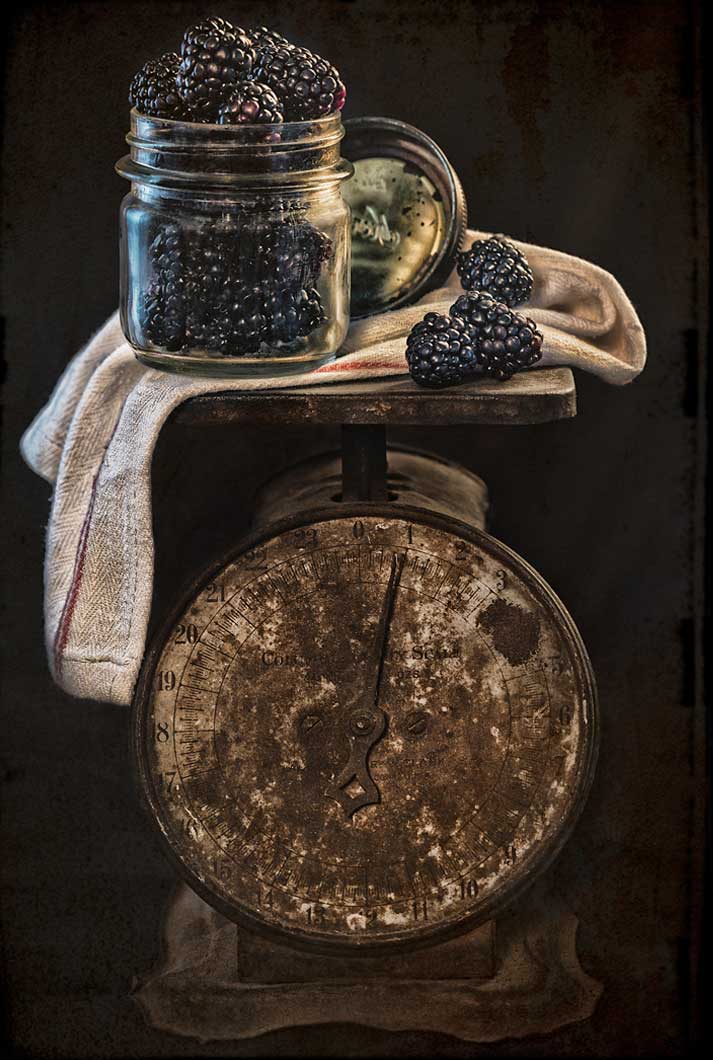 blackberries in jar sitting on the top of an antique scale for artist series Food For Thought