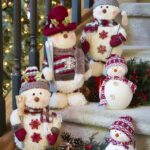 Christmas ceramic snowmen and stuffed bears with snow hats and scarfs on carpeted staircase
