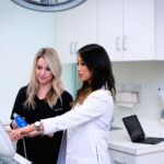 Dermatologist Jennifer Lee in a white lab coat working with a nurse in her Brentwood clinic