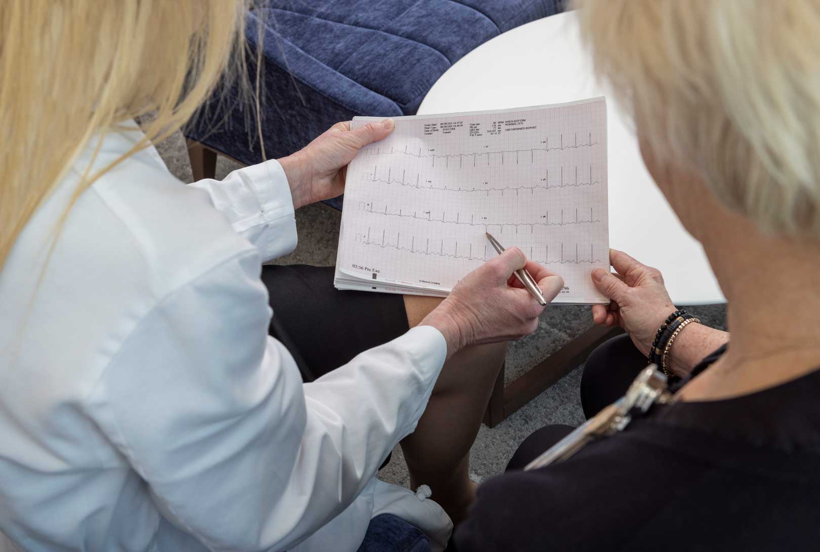 A Doctor With A Patient Reviewing An EKG Chart
