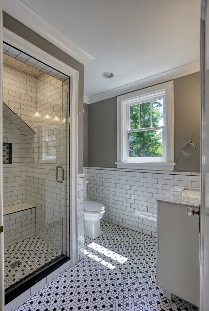 A Small Remodeled Bathroom With Black And White Tile