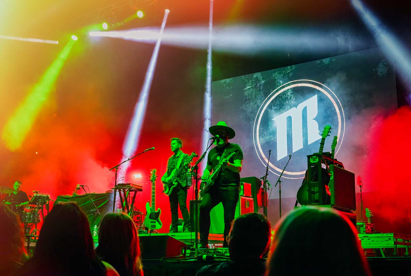 Michael Ray with his band playing live on stage with red, yellow, white, and green stage lights