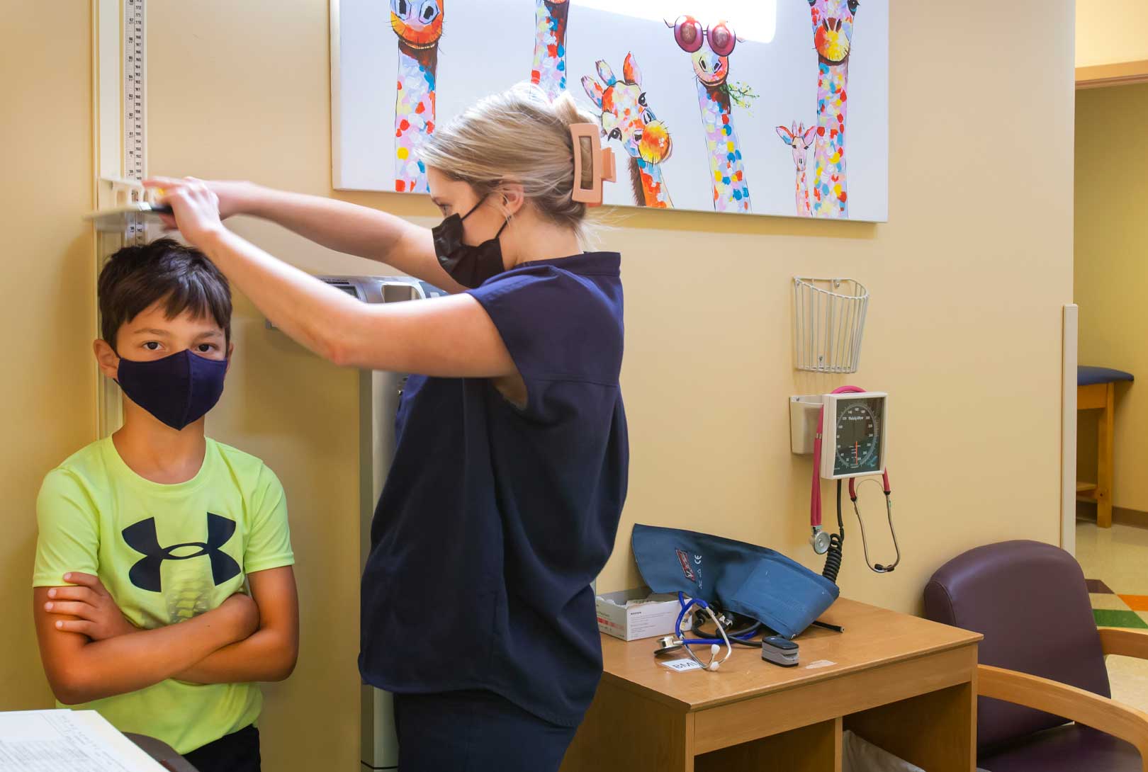 A Nurse Measures The Height Of A Boy At A Children’s Clinic