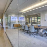 A corridor and glass-enclosed conference room at Petra Capital Partners