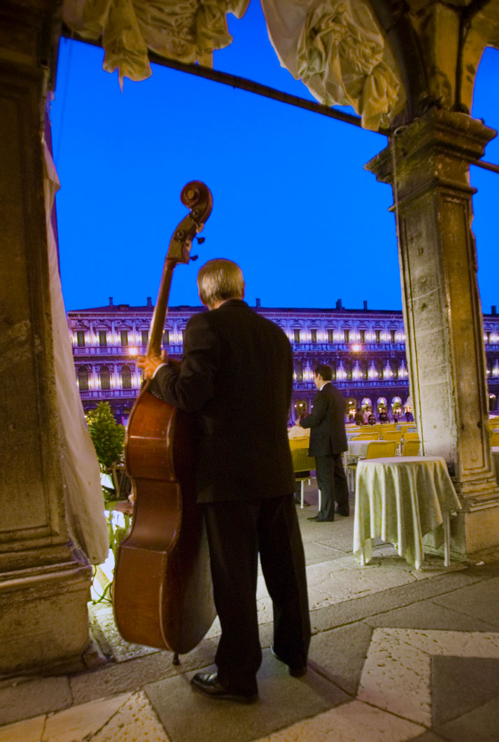 A male musician in tux playing stand-up bass in St. Peters Square in Rome Italy at dusk