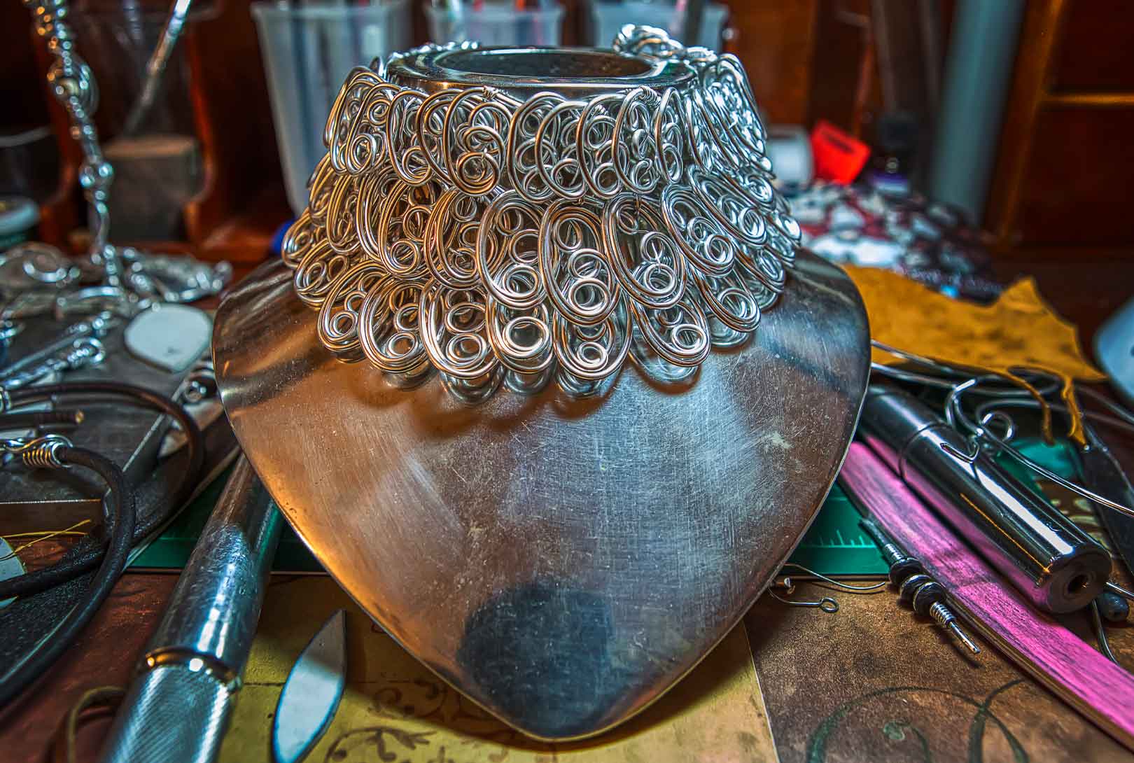 A beautiful handmade wire necklace on a chrome stand in the home studio of NashVegas Hippie Jewelry
