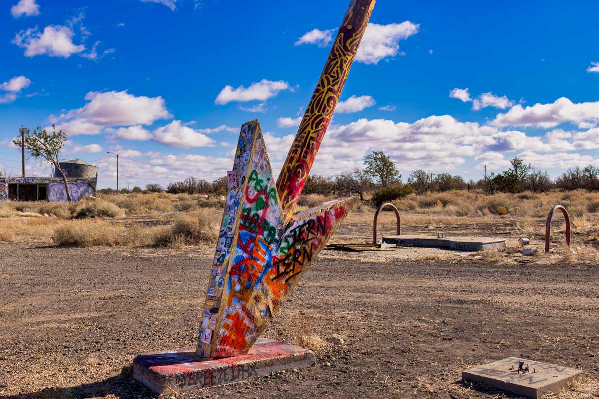 Tip of giant wooden graffiti arrow at Twin Arrows trading post building, Route 66