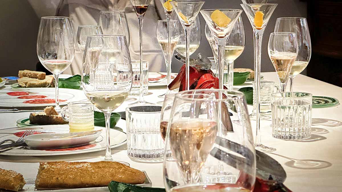A table with empty and half-full glasses, plates with food remnants, cutlery, and napkins during an 8-course lunch at the Aldofo Restaurant in Toledo, Spain.