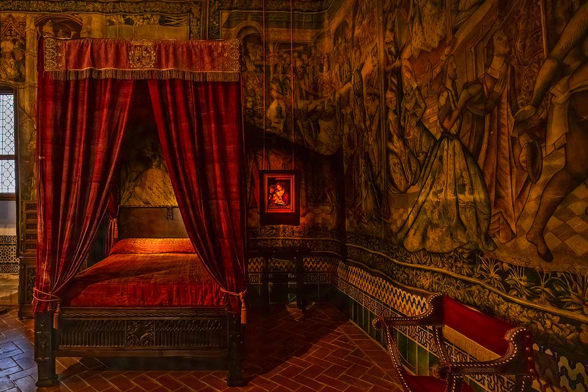 A red tapestry bedroom in the Alcazar of Segovia medieval castle in Spain