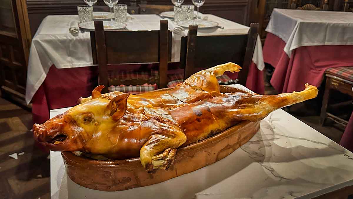 A roasted suckling pig on a table in a copper platter at the Duque Restaurant in Segovia, Spain.