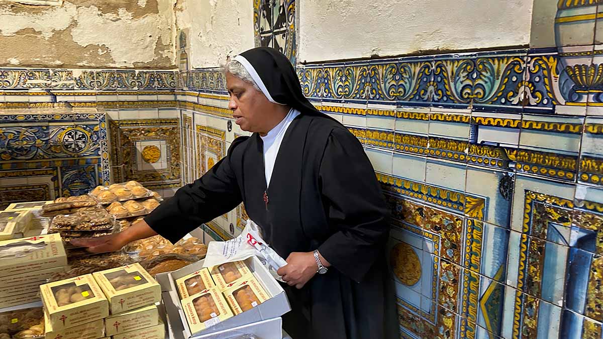 A nun at the Convent of the Comendadoras de Santiago, with marzipan and other delicious treats in Toledo, Spain.