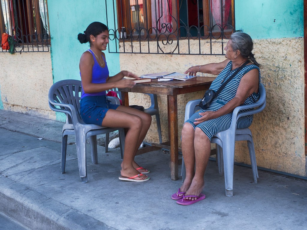 Young girl and her grandmother study school assignment in the small town of Canoa, Ecuador.