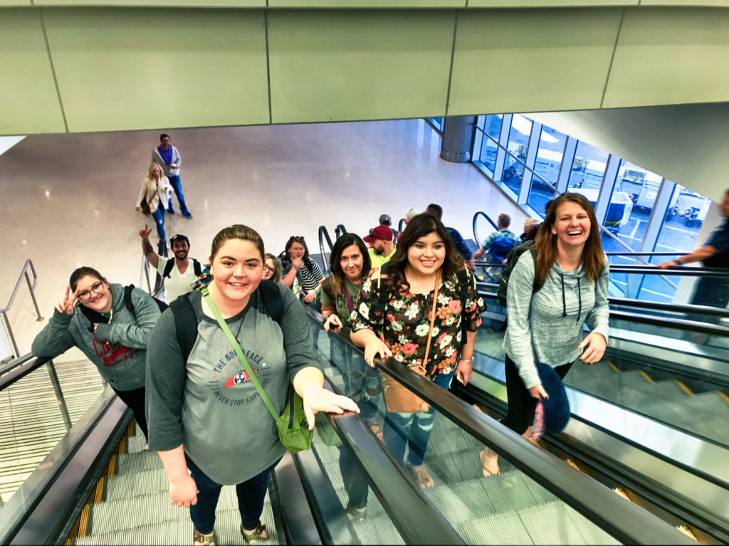 Nossi students on escalator in Miami Airport.