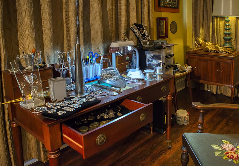 A living room desk workstation of wire jewelry, pendants and tools.